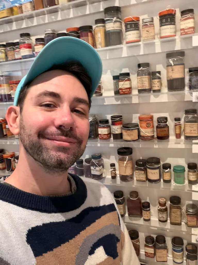 Keith smiling in front of shelves of old labeled jars of film-processing chemicals