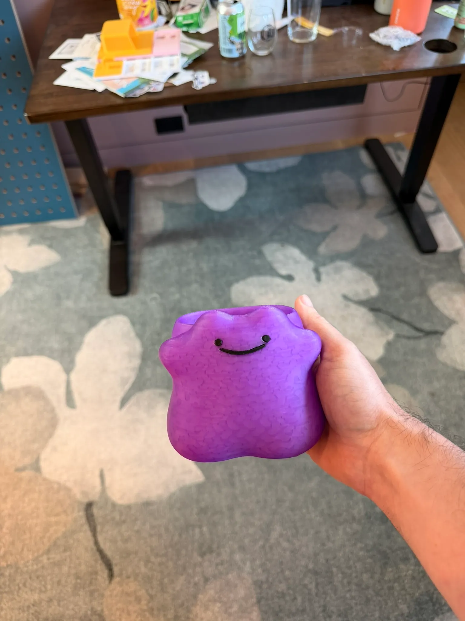 A purple, semi-translucent 3D-printed Ditto held up in Keith's hand